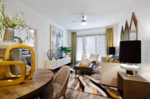 Open living room with ceiling fan and large windows