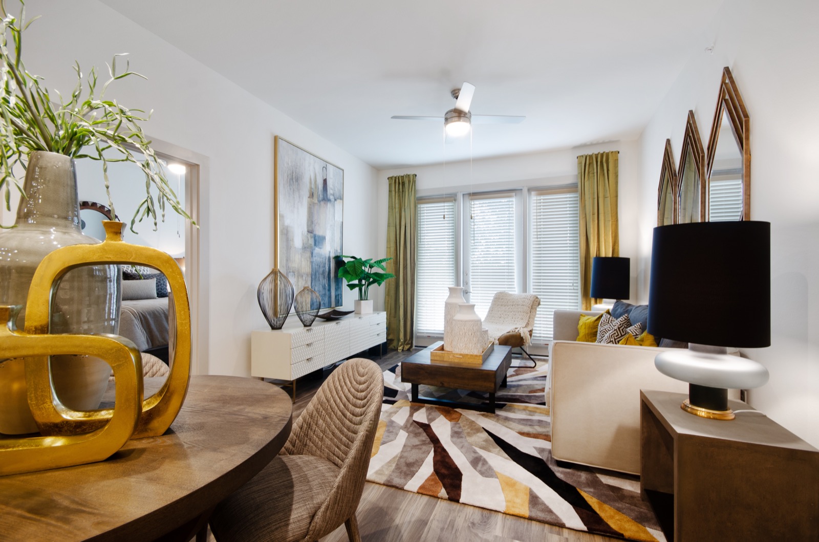Open living room with ceiling fan and large windows