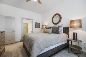 Carpeted bedroom with ceiling fan and private bathroom