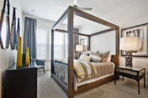 Carpeted bedroom with ceiling fan and large windows