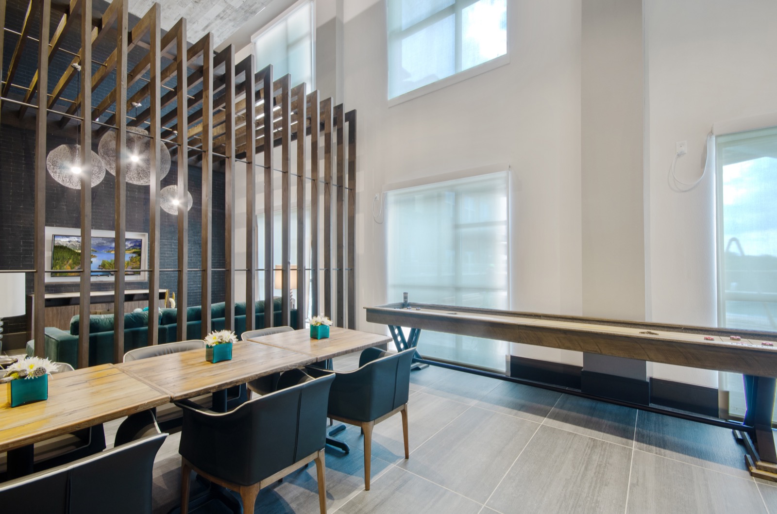 Community lounge with tables and chairs and shuffleboard tables