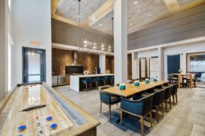 Community lounge with tables and chairs and shuffleboard tables
